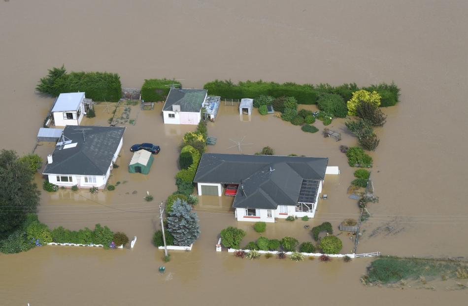 Sheds, cars and heavy machinery are swamped by the Mataura River on Wednesday.