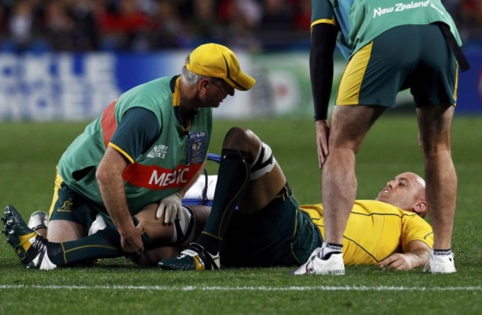 Australia Wallabies' Nathan Sharpe receives medical treatment after landing awkwardly during...