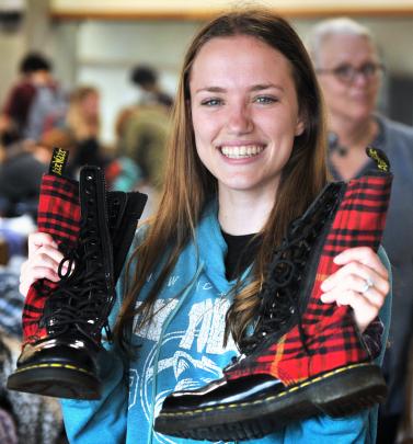 Holding a pair of near-new Doc Marten shoes bought for less than 50c is University of Otago...