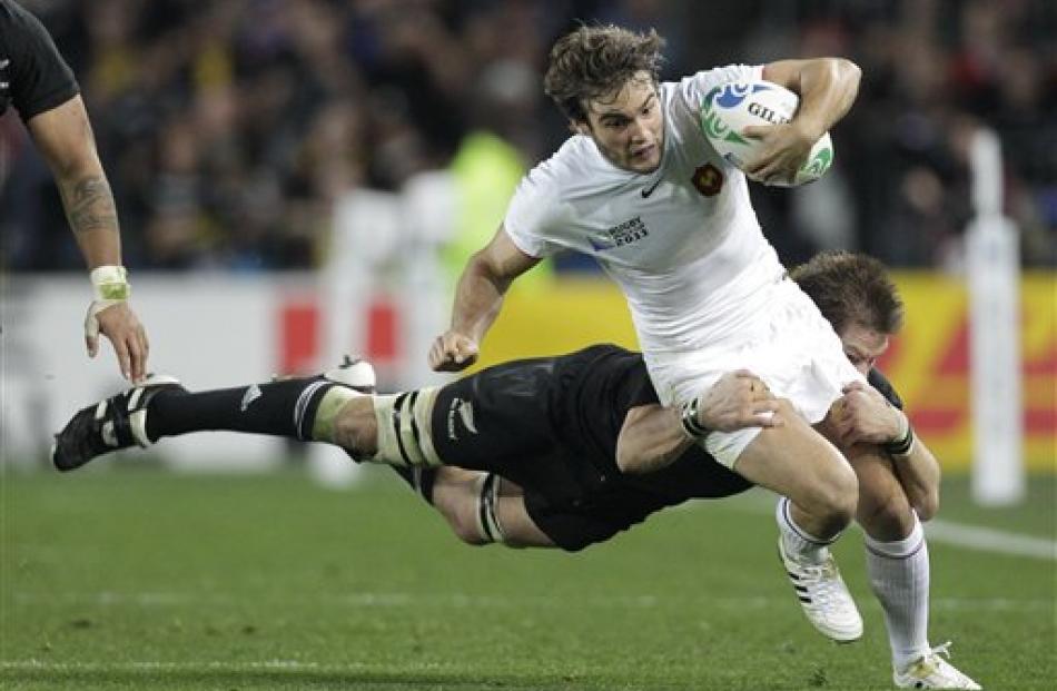 France's Alexis Palisson is tackled by Richie McCaw. (AP Photo/Themba Hadebe)