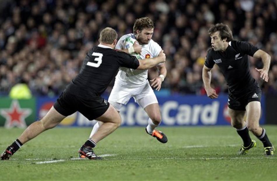 France's Maxime Medard is tackled by Owen Franks. (AP Photo/Themba Hadebe)