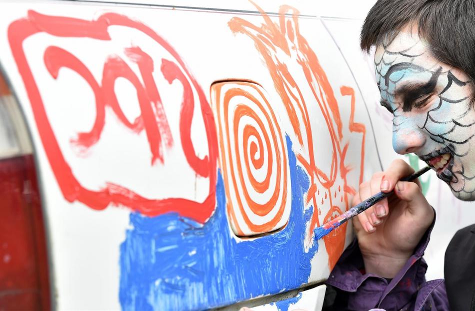 Jordan McGaughey (13), of Christchurch, paints a Mitsubishi vehicle during the Waitati Music...