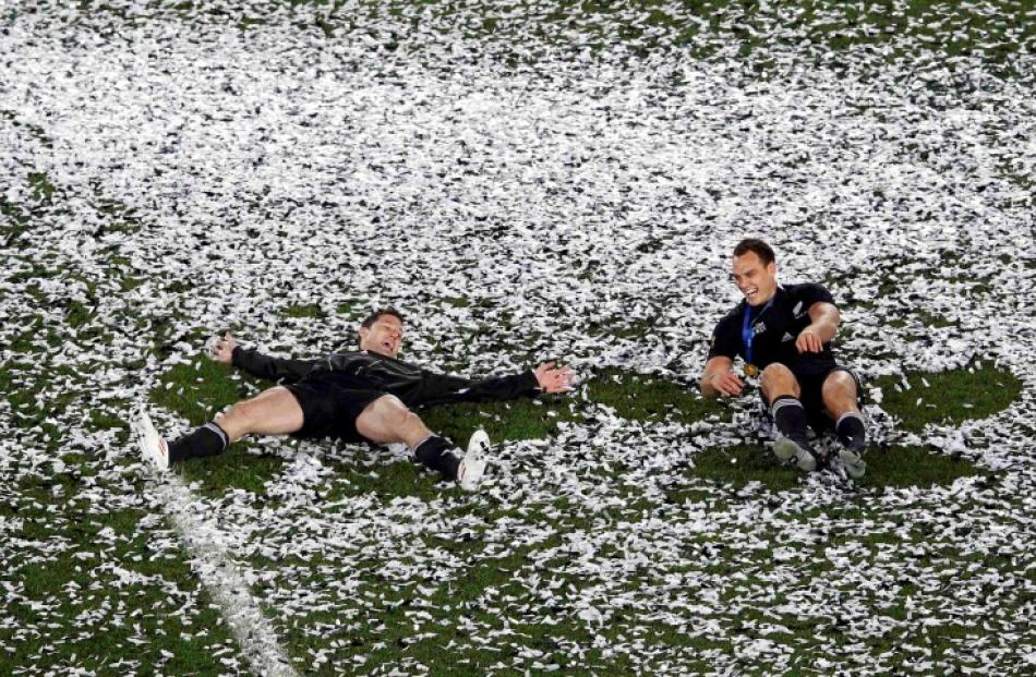 All Blacks Cory Jane (L) and Israel Dagg make confetti angels as they celebrate beating France in...