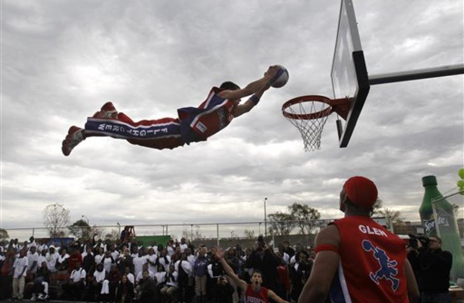 Chad Layton, a member of the Detroit Pistons Flight Crew, performs an aerial dunk on the Highland...