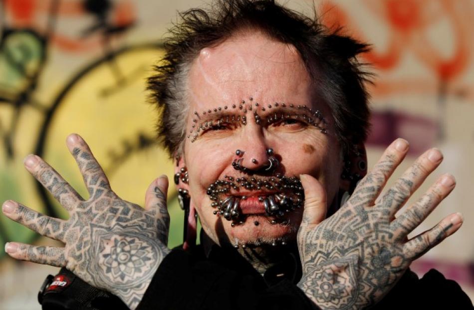 Guinness World Record holder for the 'Most Pierced Man', Rolf Bucholz of Germany, poses showing...