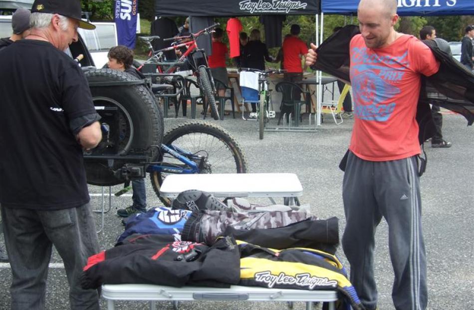 Dan Hillidge (right), of Queenstown, gets ready to try on mountain-biking body armour on offer by...