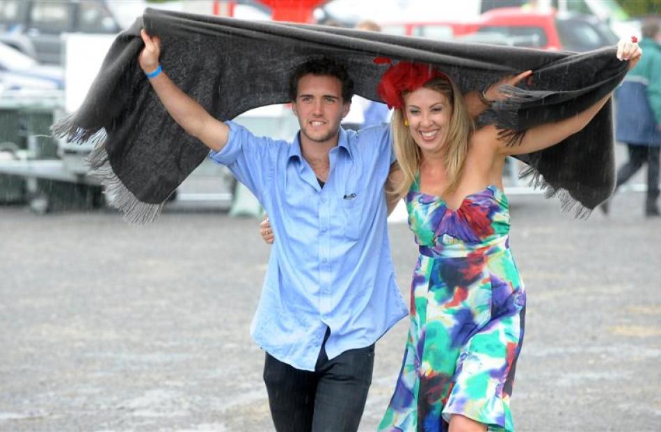 Scott Buswell and Michelle Johnson, of Dunedin, shelter from the rain at  Melbourne Cup Day at...