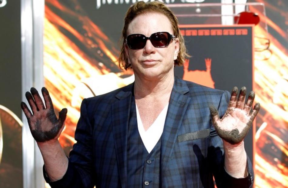 Actor Mickey Rourke shows off his hands after leaving his handprints in cement during a hand and...