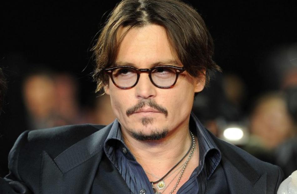 Johnny Depp poses for photographers as he arrives for the European premiere of 'The Rum Diary',...