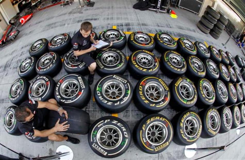 Red Bull technicans mark tires and take notes in the pit-lane ahead of the Abu Dhabi F1 Grand...