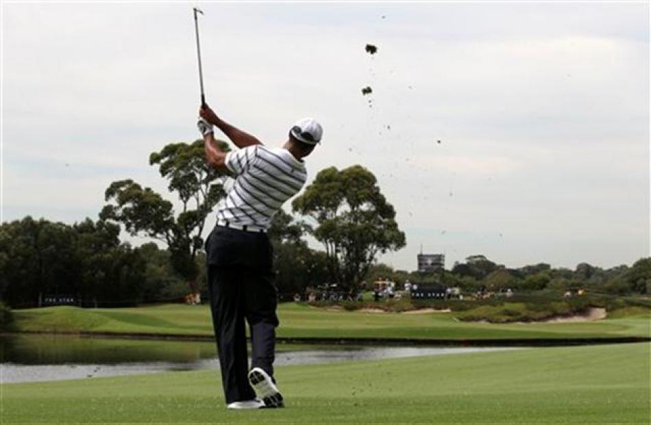 Tiger Woods plays a shot across a water hazard on the 14th during a pro-am event of the...