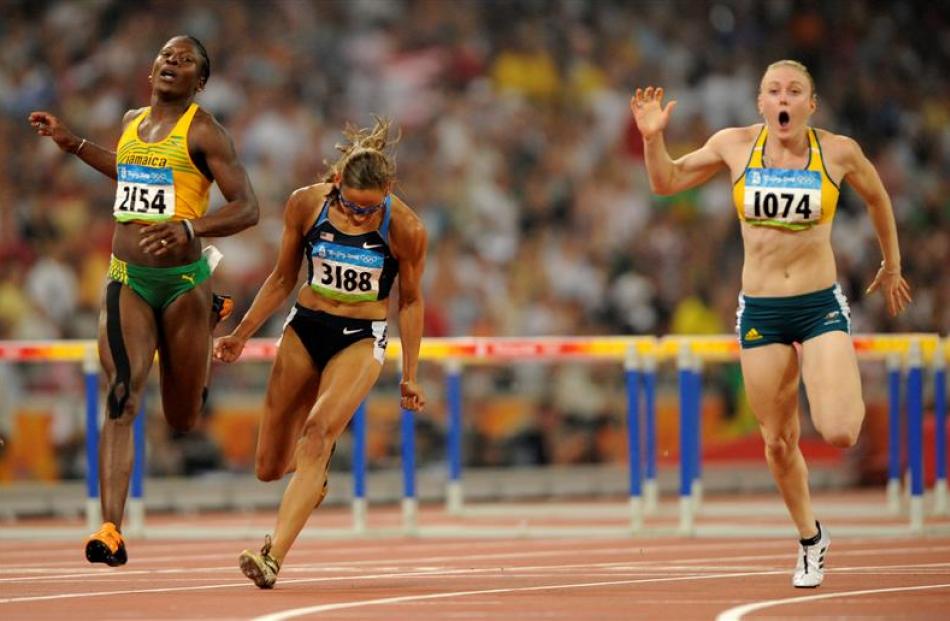 United States' LoLo Jones, centre, reacts after the women's 100-metre hurdles final. Left is...