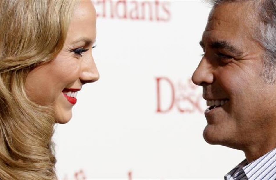 Cast member George Clooney and actress Stacy Keibler smile at the premiere of &quot;The...