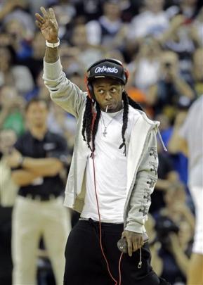Rapper Lil Wayne waves to fans as he is introduced at the co-coach of the New School Orlando...