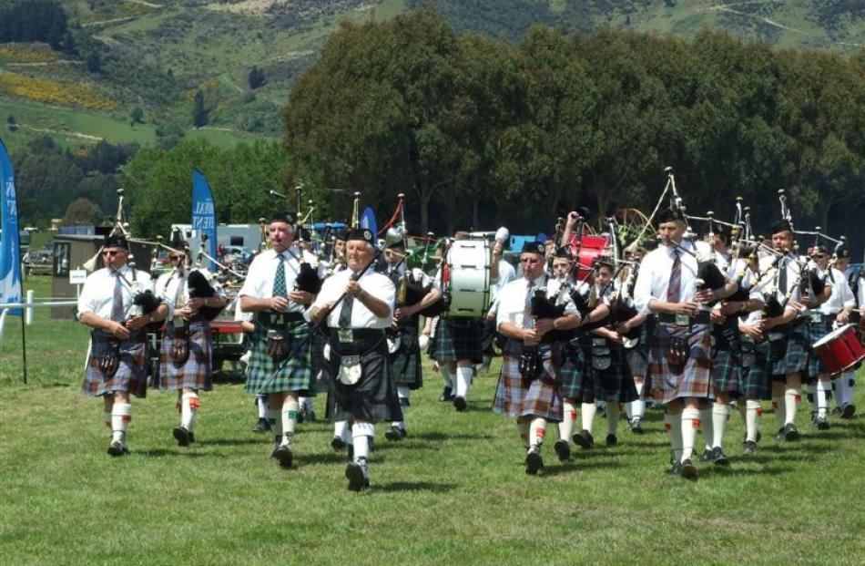 Members of the West Otago, Gore, and Alexandra pipe bands lead the grand parade.