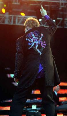 Sir Elton points to the sky.