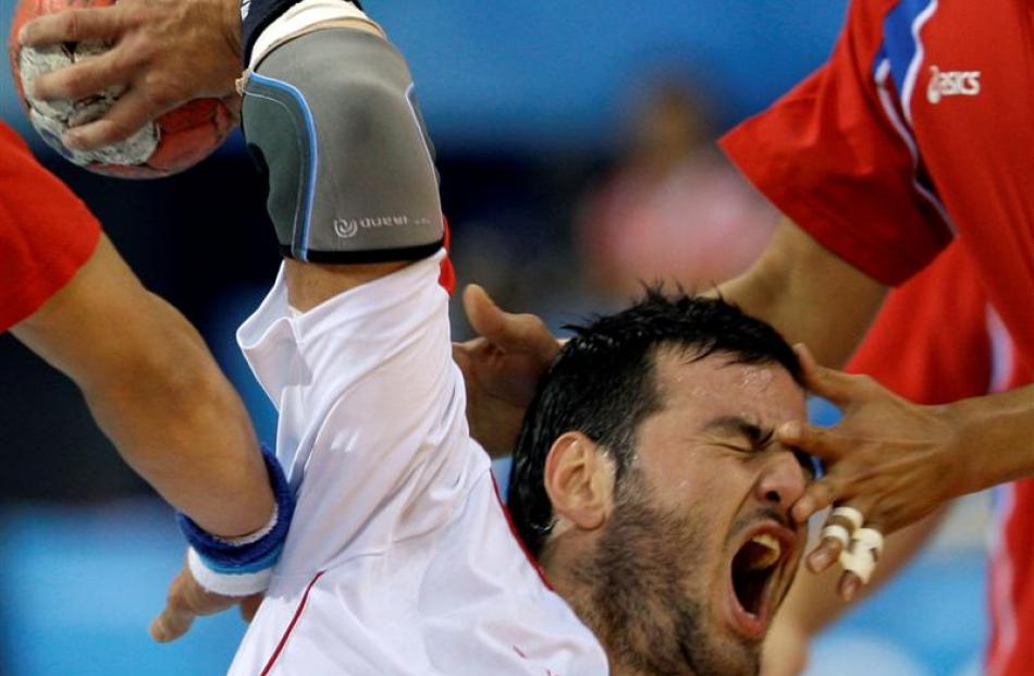 Spain's Iker Romero is tackled by Yoon Kyungmin, right, during their men's handball quarterfinal...