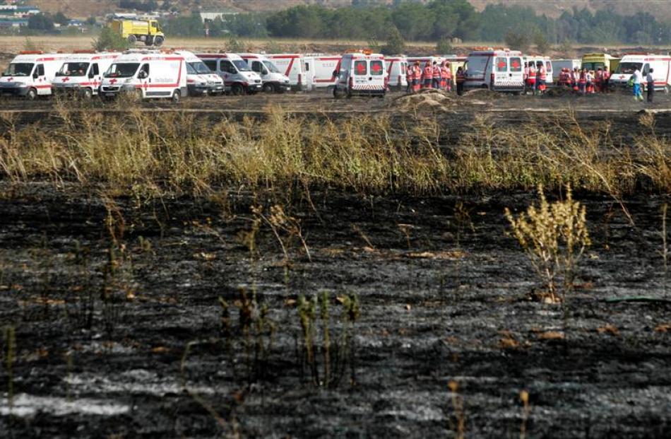 Ambulances and rescue workers gather near the site where a Spanair jet crashed on takeoff. (AP...