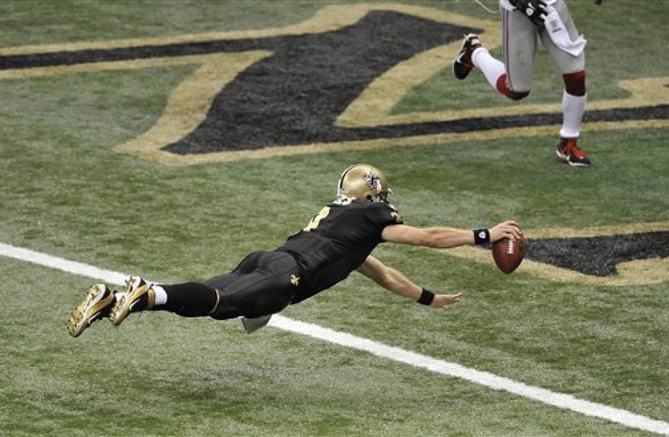 New Orleans Saints quarterback Drew Brees dives into the end zone for a touchdown during the...
