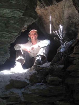 Project manager Tim Dennis rests in an extensive multi-roomed rock shelter used by early gold...
