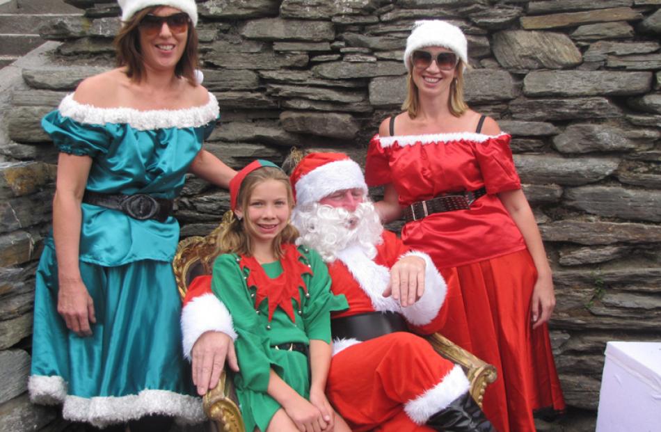 Santa's helpers Allie Blair, left, Brehna Williams (11) and Rae Williams with the man himself at...