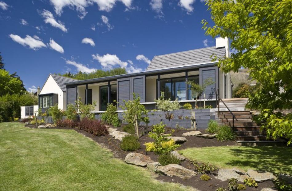 Oamaru Stone Lake Wanaka house with moveable louvre screens to protect from the morning sun and...