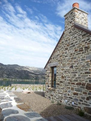 Schist cladding and courtyards used to protect Lake Dunstan house from wind.