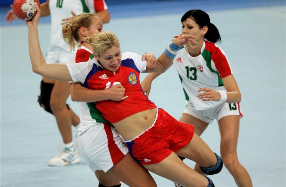 Russia's Elena Dmitrieva is tackled by Hungary's Monika Kovacsicz during the women's handball...