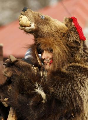 A man dressed in a bear costume takes part in a traditional fair for Christmas and New Year...