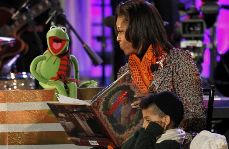US first lady Michelle Obama reads a Christmas story to children with the help of Kermit the Frog...
