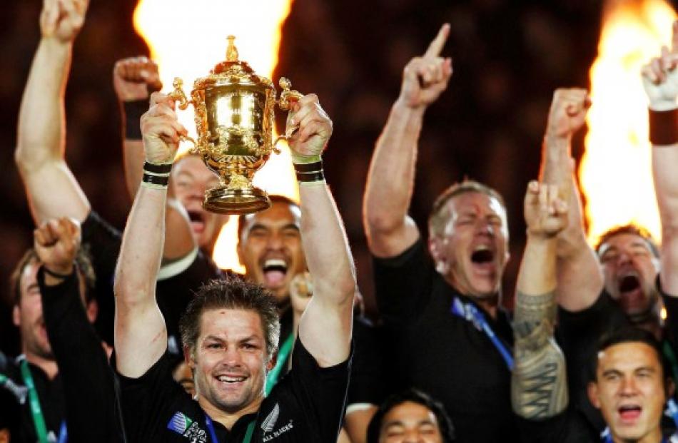 All Black captain Richie McCaw holds up the Webb Ellis Cup after his team beat France to win the...