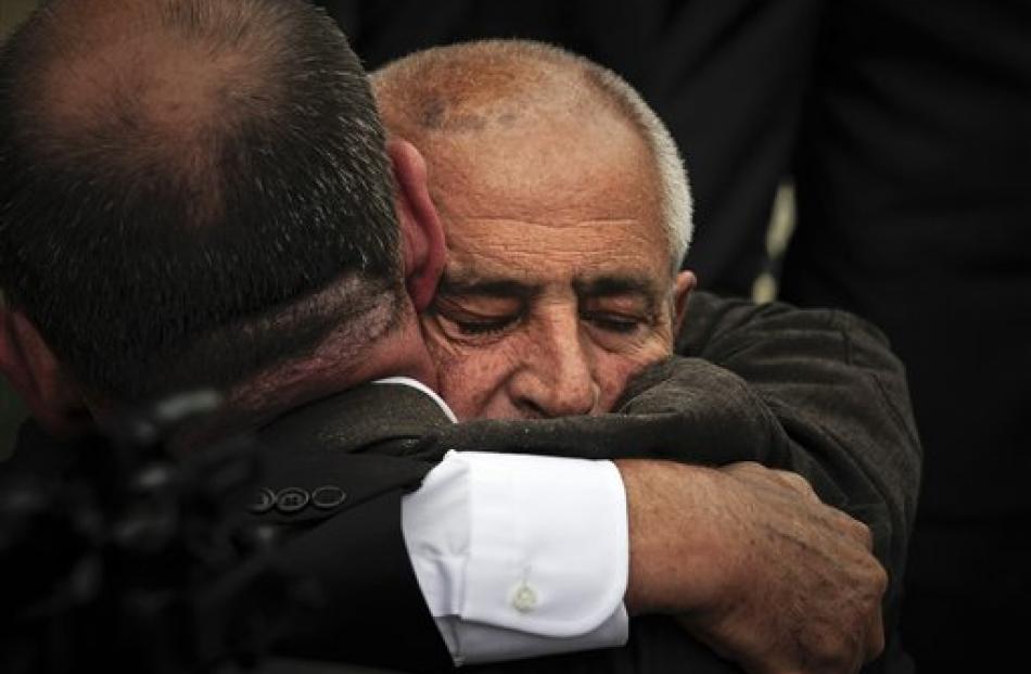 Baldomero Ballesteros, right, is comforted at the end of the funeral service of his brother,...
