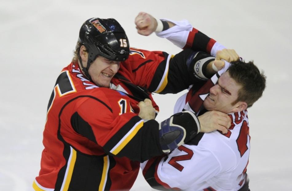 Calgary Flames' Tim Jackman (L) and New Jersey Devils' Eric Boulton exchange blows in their fight...
