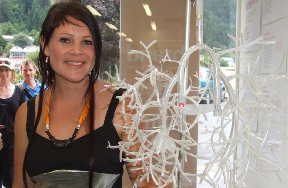 Exhibition creator Jessica Winchcombe, wearing her own creation, poses with a piece by  Nadene...