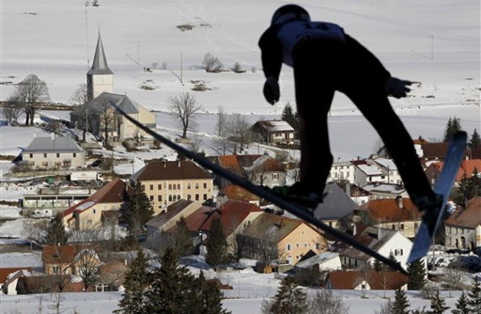 A skier flies through the air during the jumping portion of the Nordic Combined Ski World Cup of...