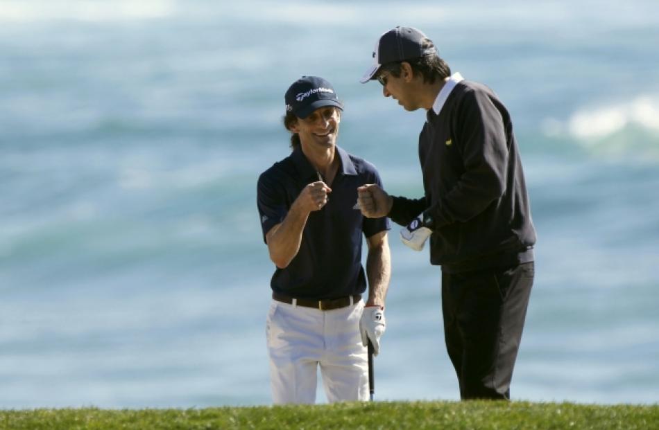 Actor Ray Romano (R) and musician Kenny G bump fists at the 18th hole during the Celebrity...