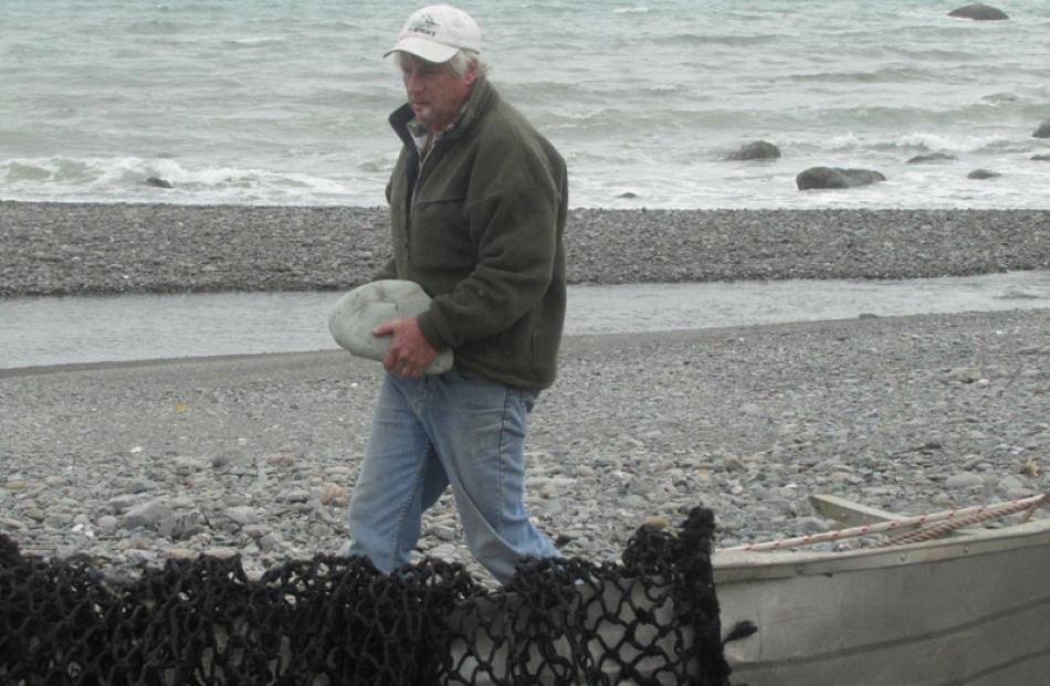 Pilot Geoff Robson gathers rock ballast for his helicopter load.