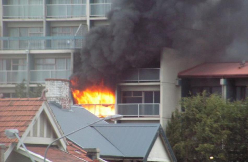 Flames erupt from the  third-floor room. Photo by David Winter