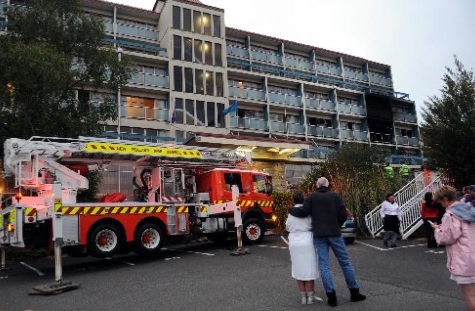 Rose and Dave Stevenson, of Christchurch, watch as firefighters work to dampen down a fire at the...