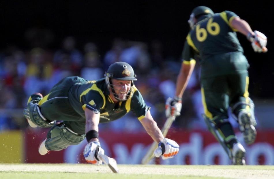 Australia's Mike Hussey dives to make a run against India during their one-day international...