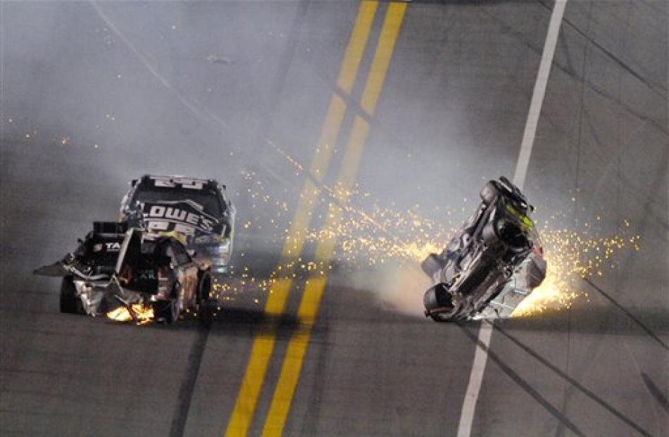 Jeff Gordon, right, flips over after colliding with Kurt Busch, left, as Jimmie Johnson drives...