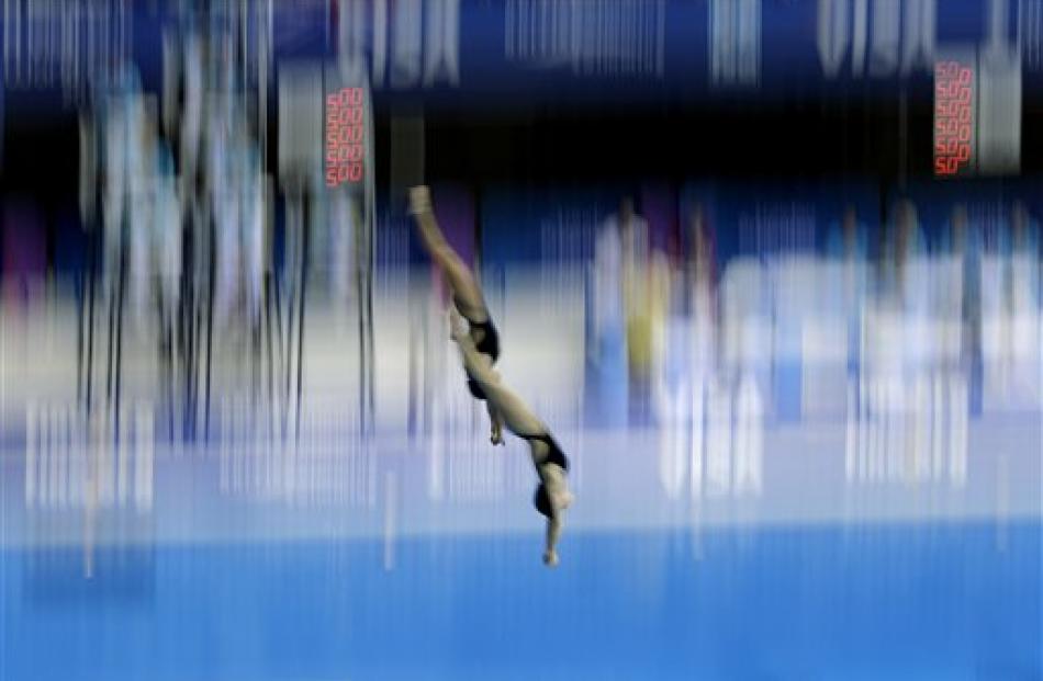 Romania's Mara Elena Aiacoboae and Adina Maria Topolinschi perform a dive during the semifinal of...