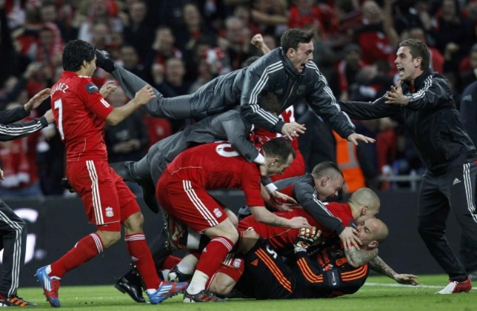 Liverpool's players react after winning the English League Cup on penalties against Cardiff City...