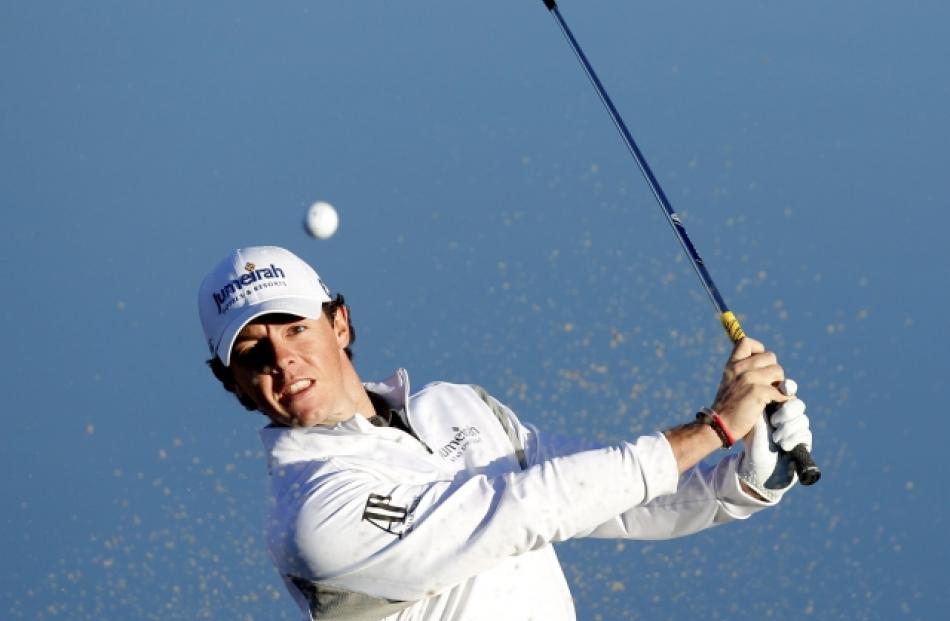 Rory McIlroy of Northern Ireland hits his second shot from the sand on the third hole during the...