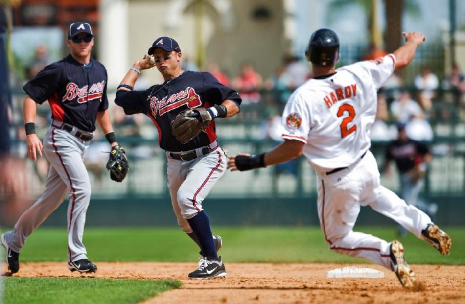 Atlanta Braves shortstop Tyler Pastornicky (L) watches as second baseman Martin Prado (C) throws...