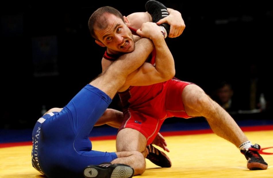 Radoslav Velikov of Bulgaria (red) and Mihran Jaburyan of Armenia compete at the men's 55kg...