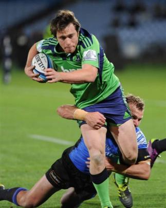 Ffullback Ben Smith, wearing the controversial green jersey, tries to beat a Force defender last...