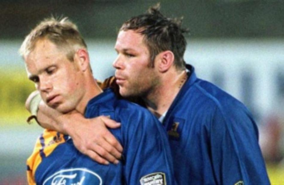 Josh Kronfeld consoles Jeff Wilson after the semifinal loss to the Crusaders in 2000.