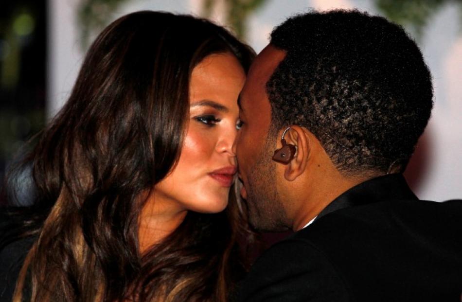 Singer John Legend and his girlfriend Chrissy Teigen kiss at the State Dinner held to honour...