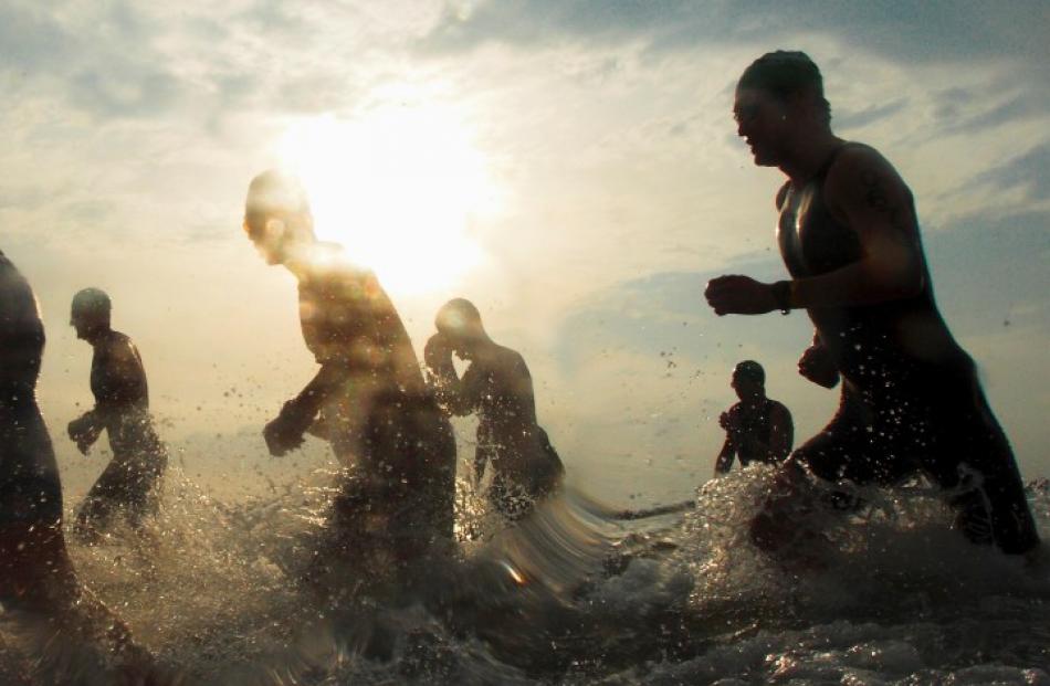 Triathletes exit the water during the Ironman 70.3 Triathlon in Singapore. REUTERS/Tim Chong